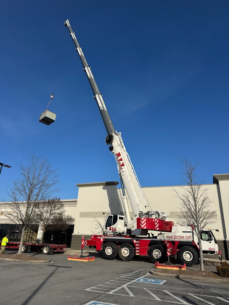 Lifting a rooftop unit into place via crane by Buckner Plumbing